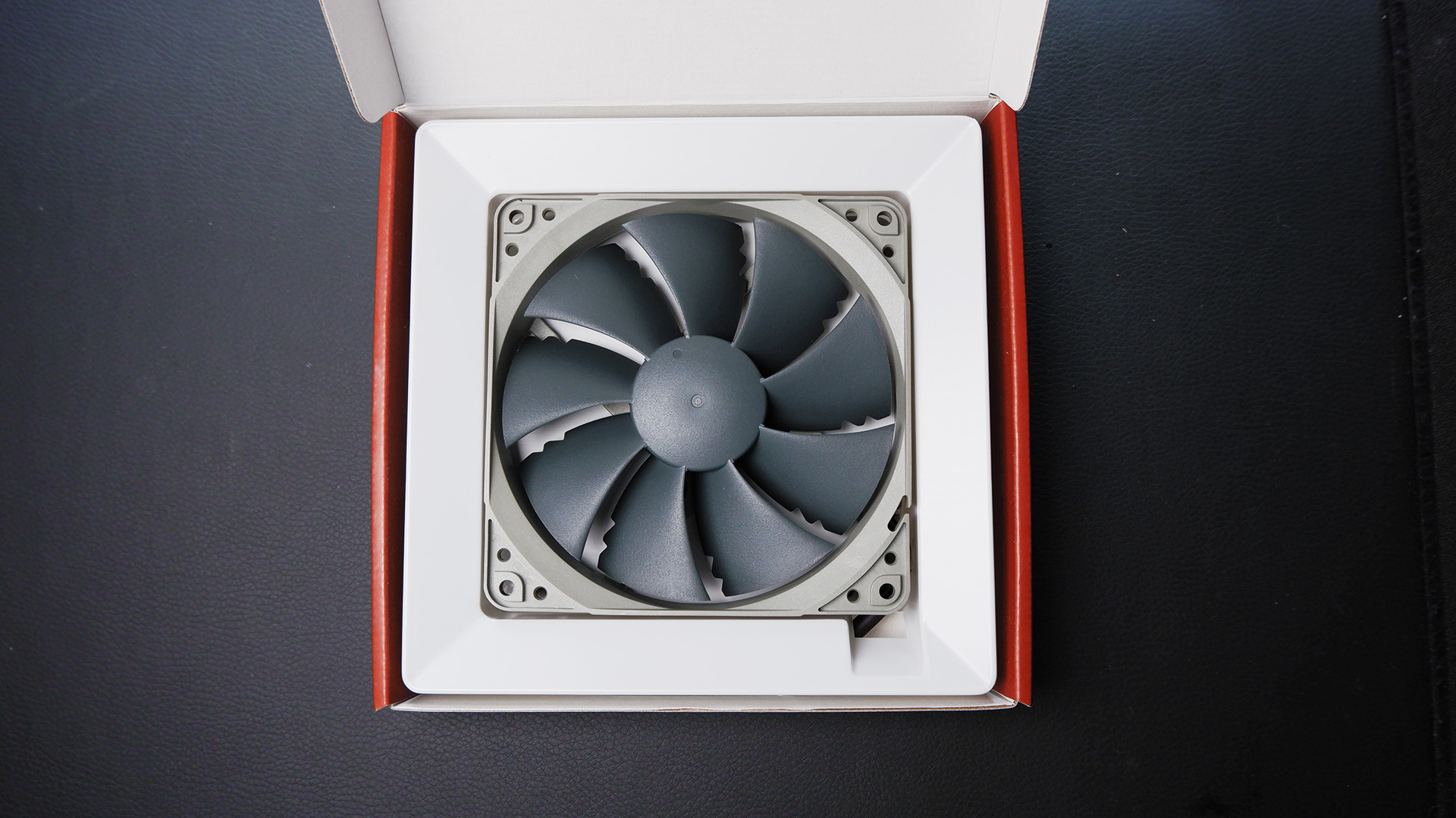 Noctua fans sitting on a desk with boxes.