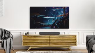 La soundbar Denon Home 550 in un salotto, disposta su un tavolo in legno