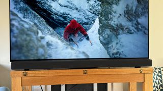 Sony Bravia Theatre Bar 9 in front of TV screen showing mountain climber