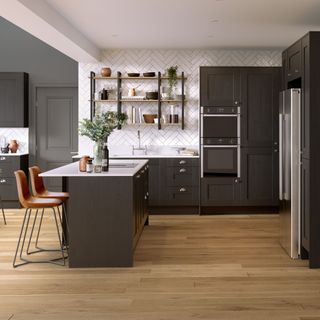 Dark grey kitchen cabinets with white countertops and matching island
