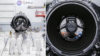 technicians in clean suits in a hangar next to a large rectangular spacecraft wrapped in metallic foil