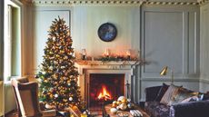Period living room with navy velvet sofa, fireplace, and Christmas tree
