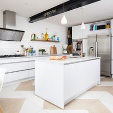 kitchen room with white tiled walls and kitchen chimney