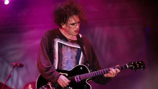 Robert Smith of the Cure performs onstage at the Glastonbury Festival in 1995