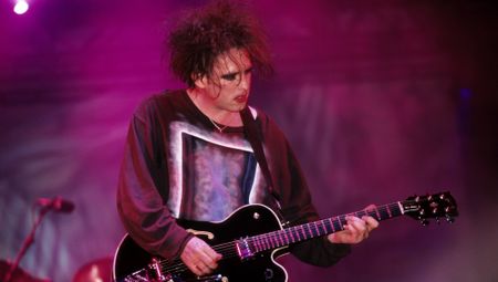 Robert Smith of the Cure performs onstage at the Glastonbury Festival in 1995