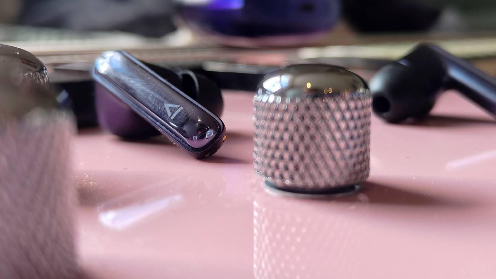 The Creative Aurvana Ace 3 buds on a pink bass guitar.