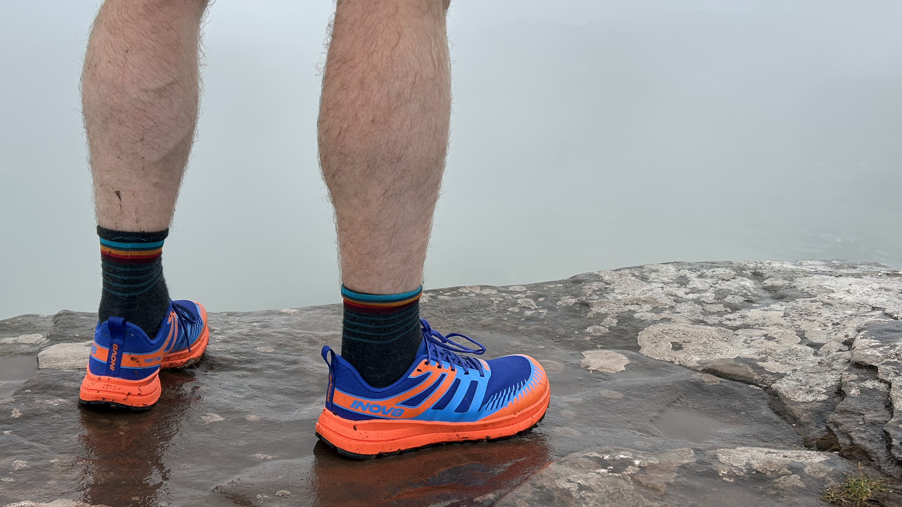 Runner standing on a wet rock
