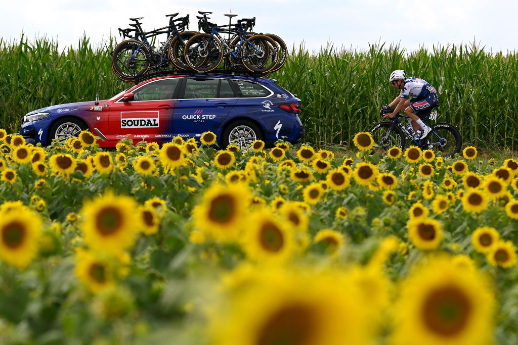 Peloton races by fields of sunflowers