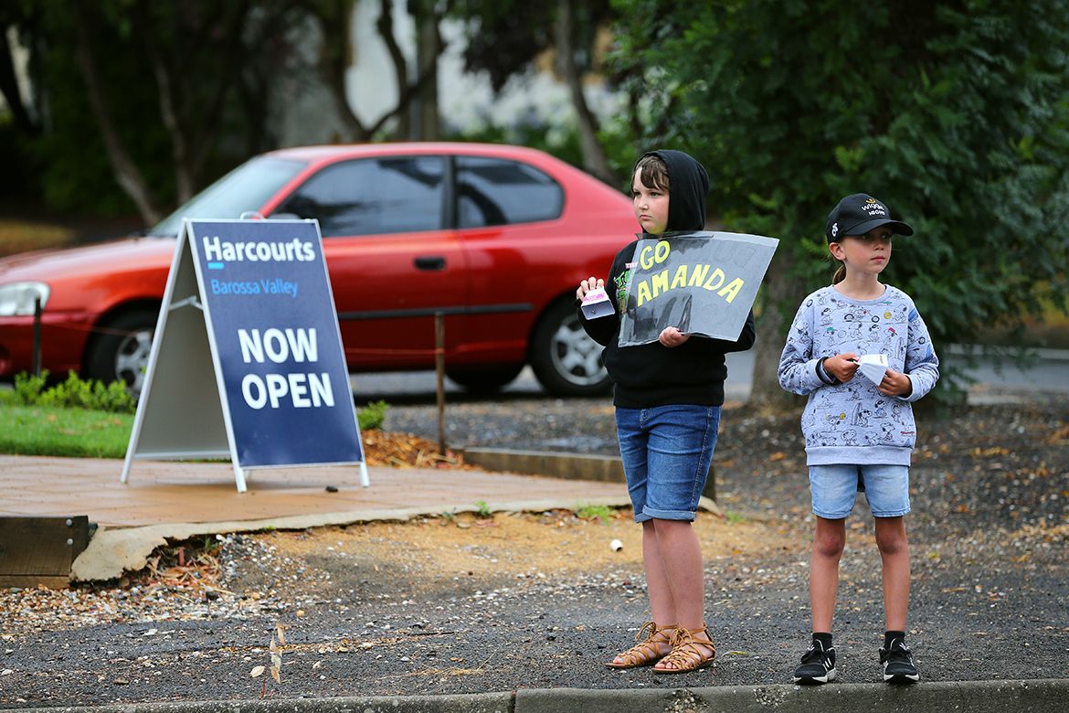 Amanda Spratt fans wait for the peloton