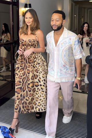 Chrissy Teigen wearing a leopard print dress with John Legend.