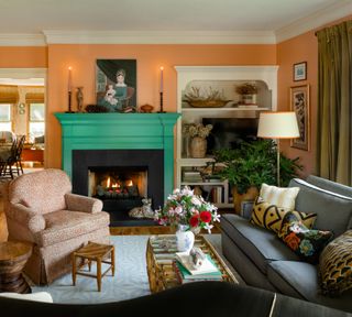 A living room with orange walls and a green fireplace