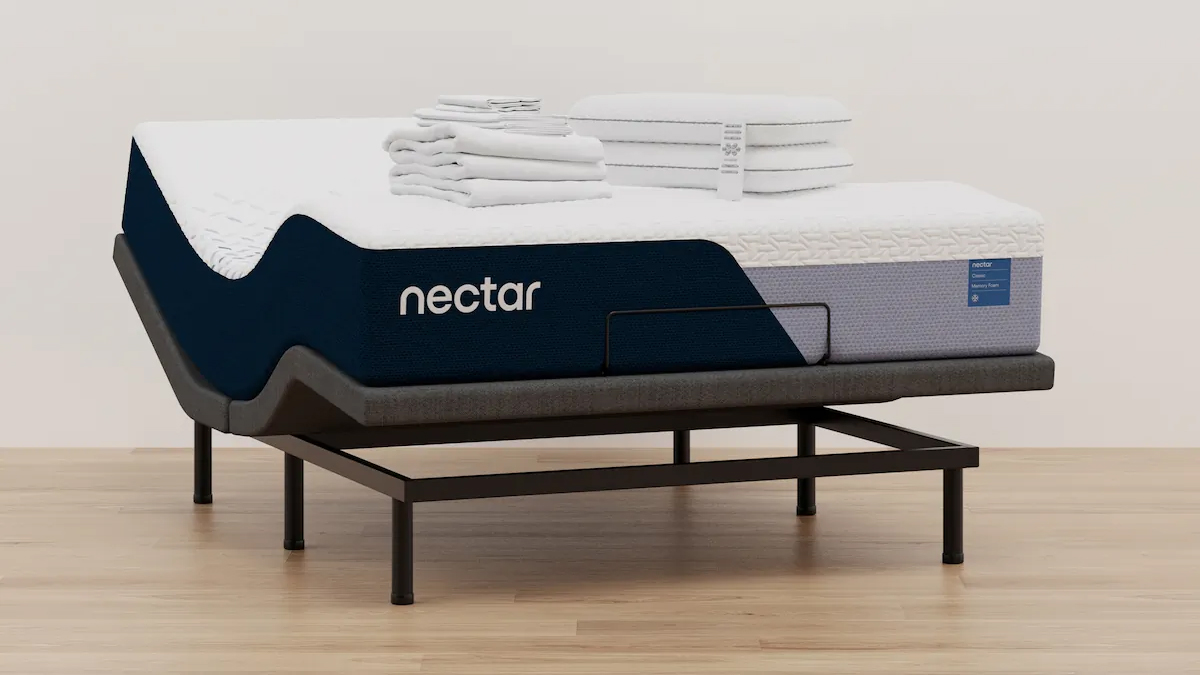 The Nectar adjustable bed frame with the Nectar Classic Memory Foam Mattress, a neatly folded bedding bundle placed on top. The head and feet of the bed frame are raised into Zero Gravity Position
