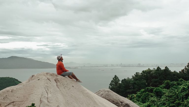wilderness trips: man sat on a rock looking across water