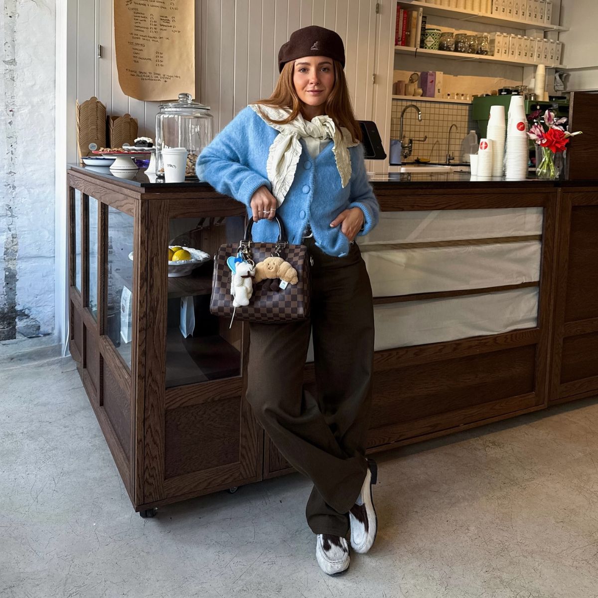 Girl wearing animal print shoes in cafe holding bag