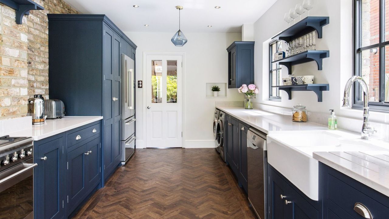 galley kitchen ideas featuring blue cabinetry and wooden herringbone flooring