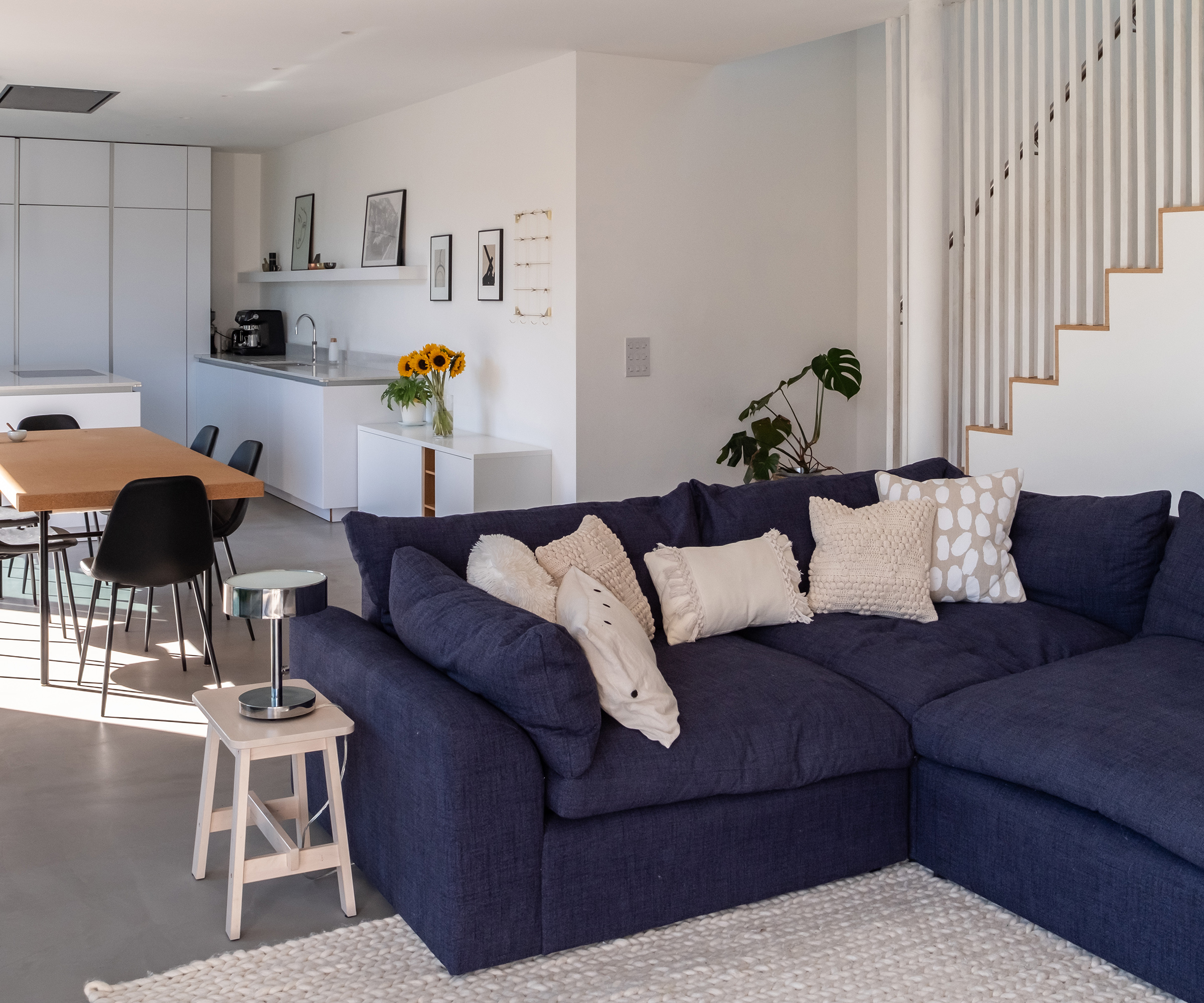 An open plan kitchen and dining room space with large corner sofa