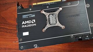 Close up of AMD Radeon RX 9070 backplate logo on woodgrain desk.