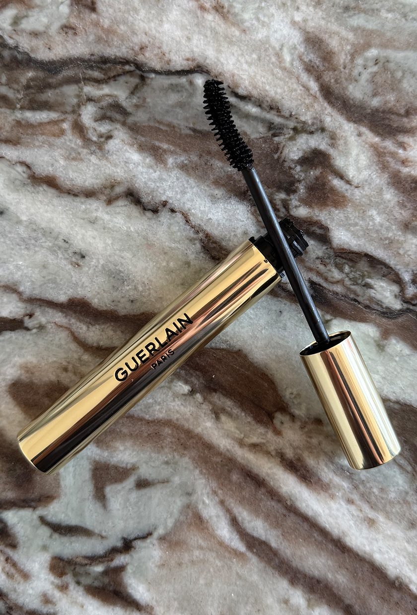 Guerlain G Noir mascara wand and case on marble table