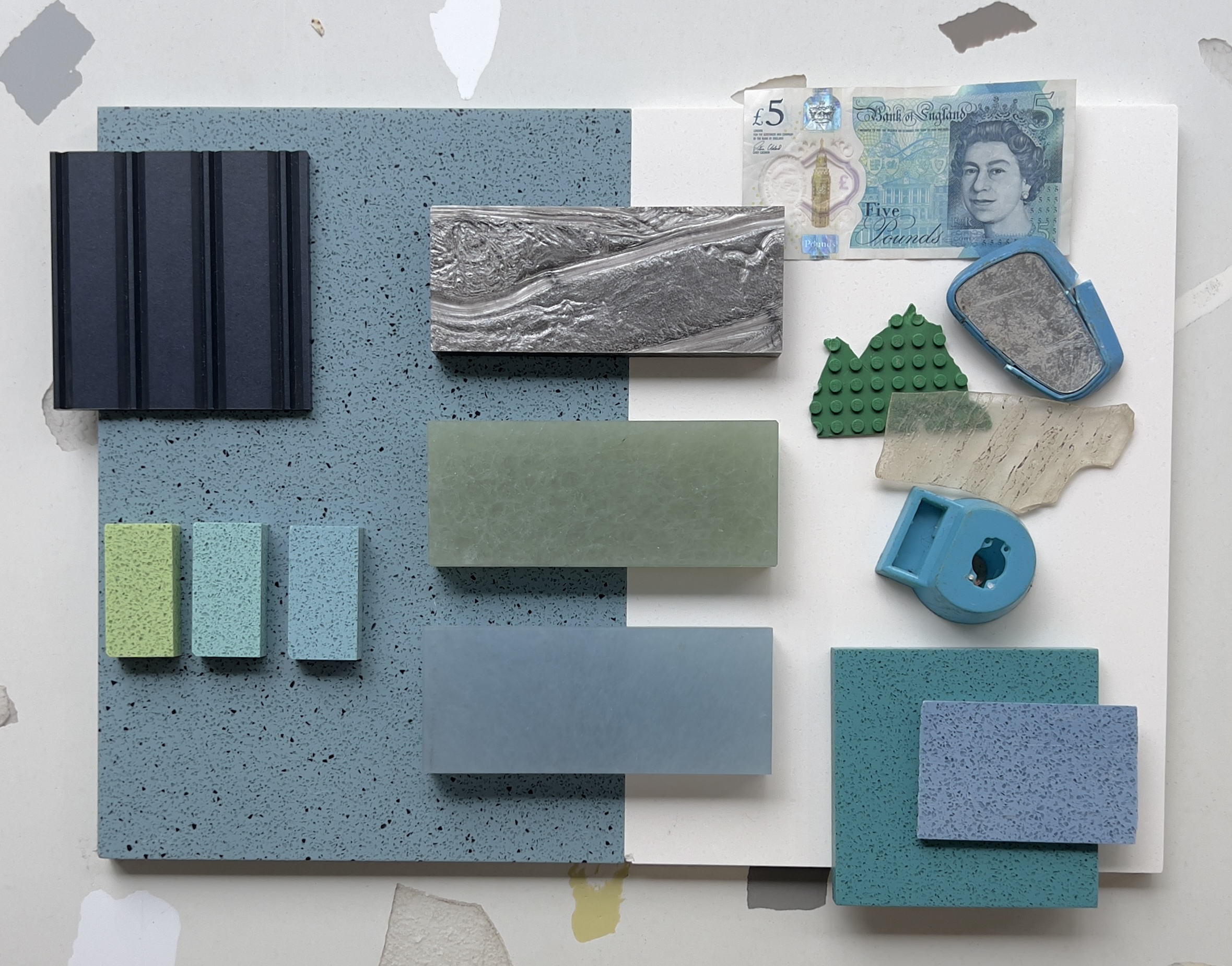 A palette of materials in blue, including a blue five pound banknote