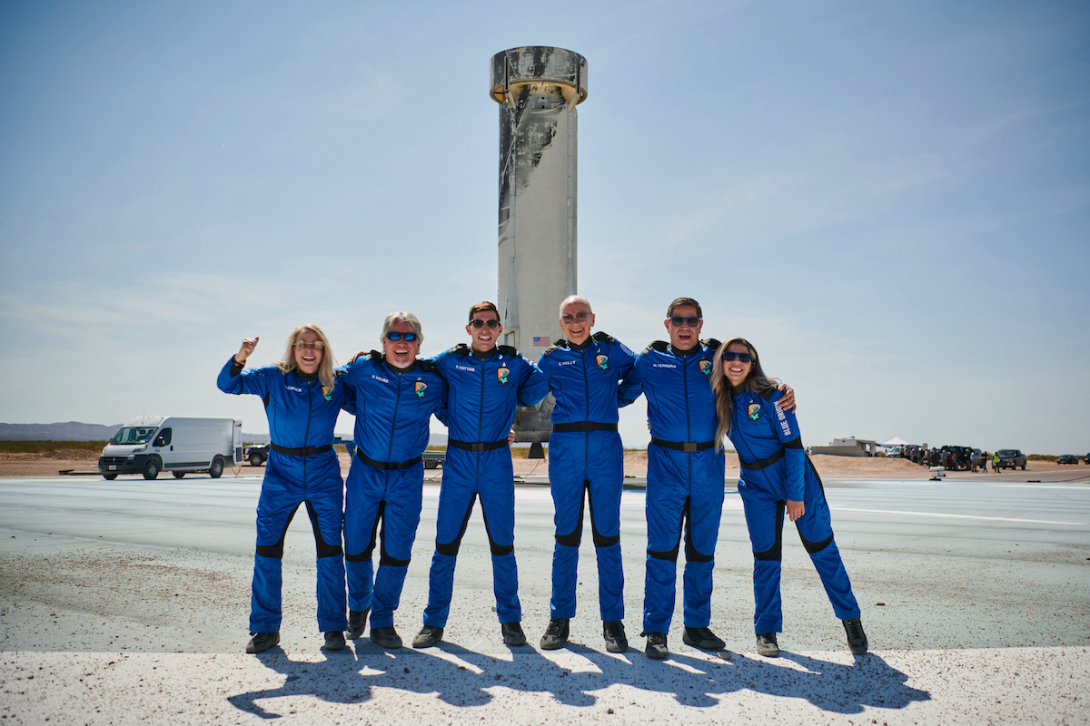 people standing in front of rocket