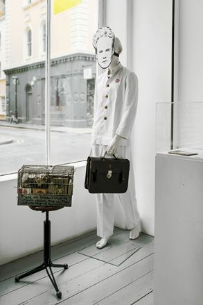 Mannequin in white suit with Briefcase and Mask.