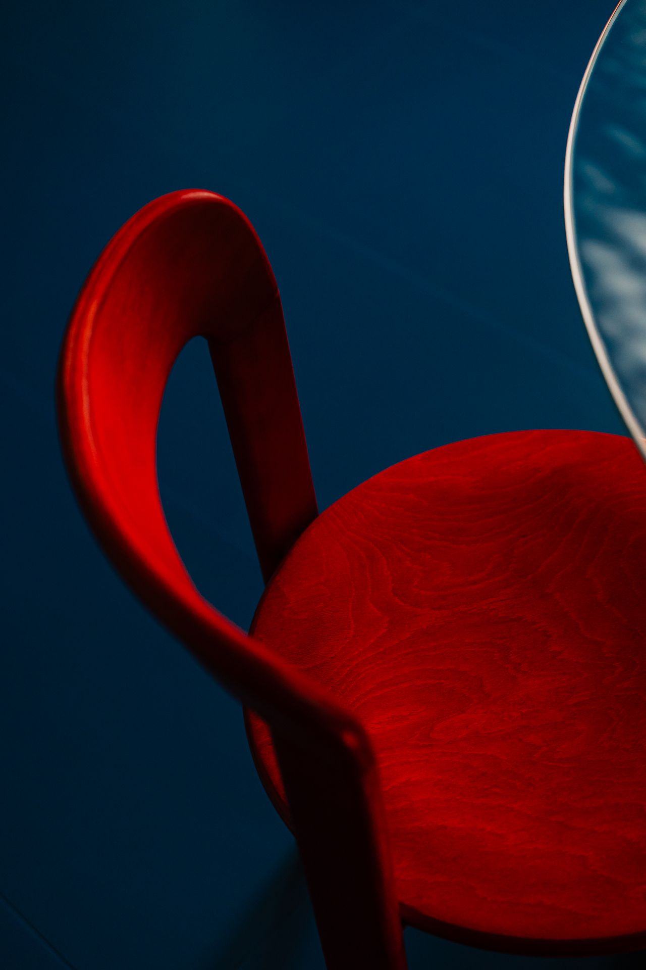 A view over a red chair atop an International Klein Blue floor.