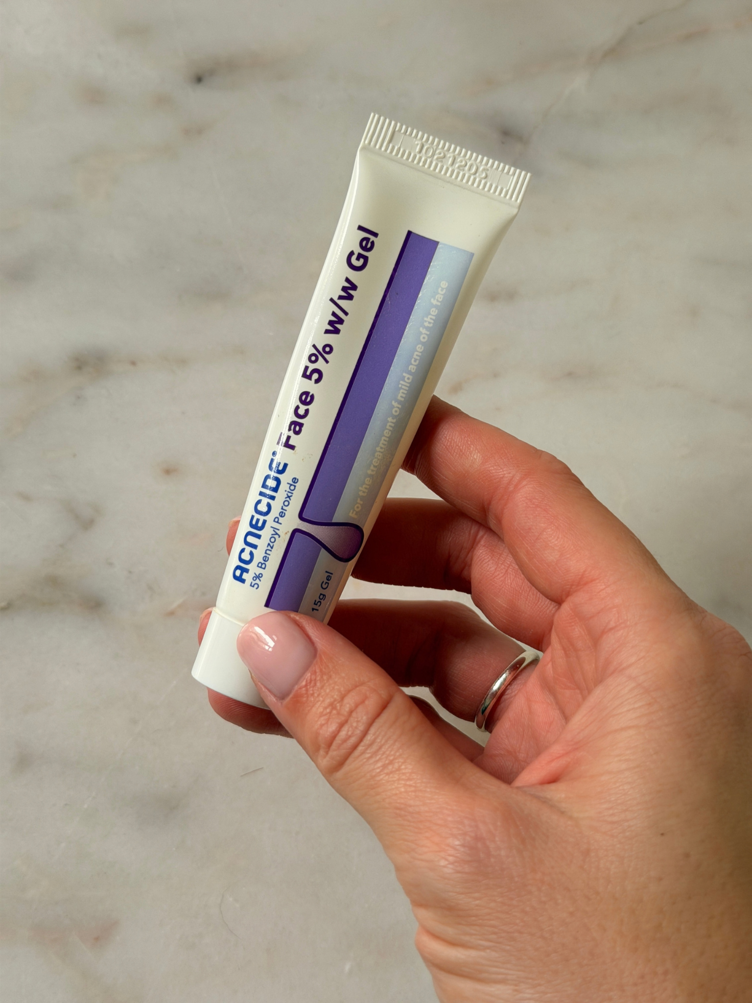 Freelance beauty editor Grace Day holding the Acnecide spot treatment