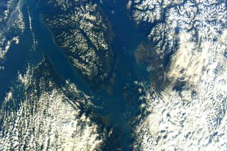 This striking image captured by JAXA astronaut Soichi Noguchi shows Olympic National Park in Washington State along with Vancouver in Canada. The astronaut snapped the photograph from the International Space Station and shared the colorful view on Twitter. The photo shows the blue of the water separating the blocks of land, most of which is speckled and coated with a thick billowy layer of clouds.