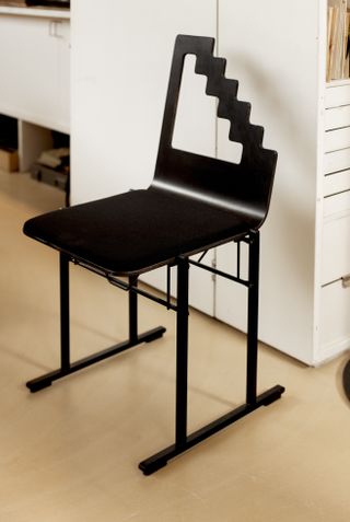 Black metal chair with cut-out back, by Yrjö Kukkapuro