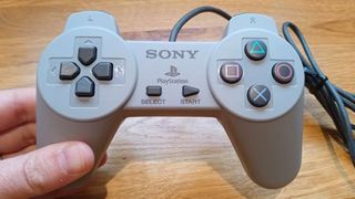 A photo of the PlayStation classic's controller held over a wooden table