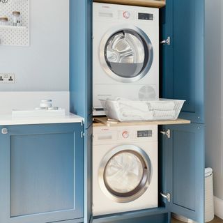 utility room with blue cabinet with washing machine