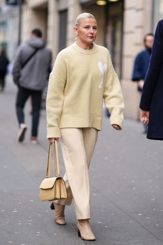 Woman in butter yellow jumper and trousers GettyImages-2136314571