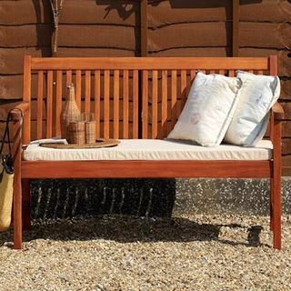 wooden bench with cushion and fence