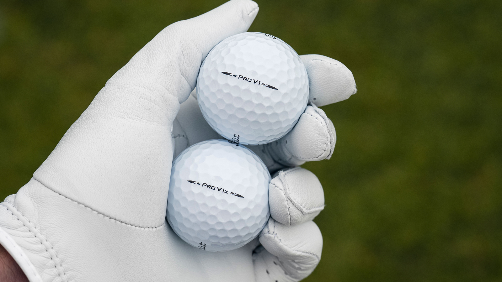 Two Titleist golf balls in a golf glove