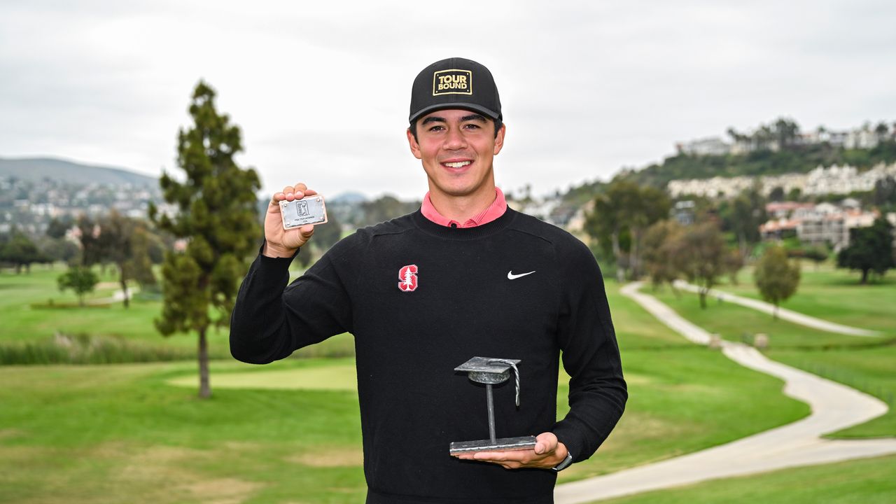 Michael Thorbjornsen holds up his ceremonial PGA Tour and the PGA Tour U trophy while smiling