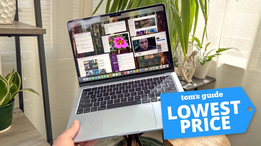 MacBook Air M4 in hand in room with plants in background with Tom's Guide Lowest Price badge