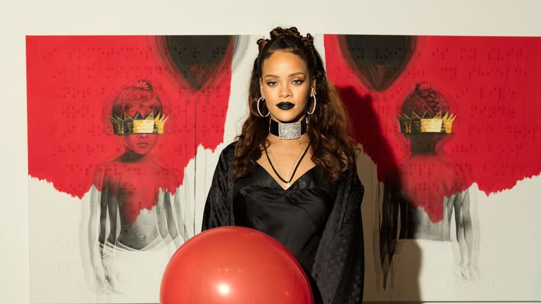 Rihanna holding a red balloon.