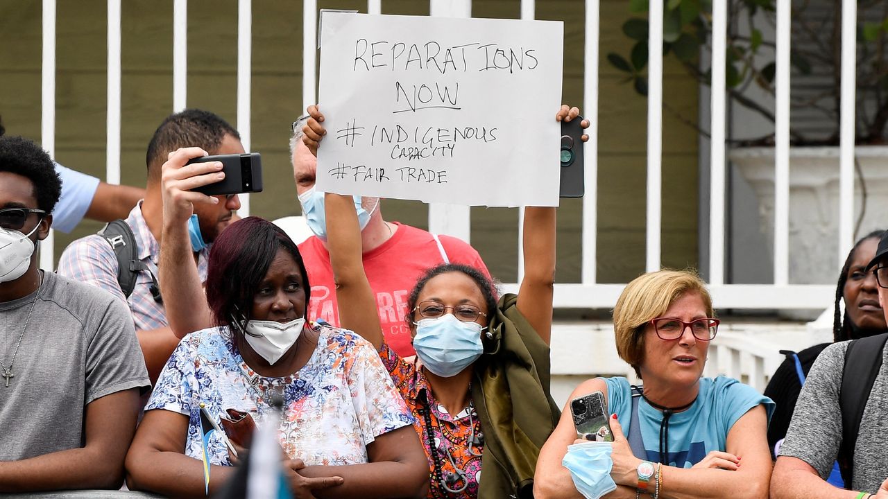 A woman in the Bahamas protests before the arrival of the Duke and Duchess of Cambridge