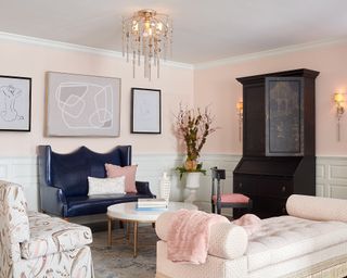 Eclectic mix living room with half wall panelling in neutral shade, and blush pink upper walls, and curves trend wall art.