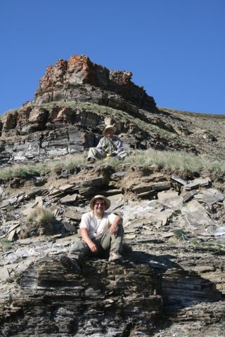 Professors Alan J. Kaufman (University of Maryland, front) and Shuhai Xiao (Virginia Polytechnic Institute and State University, back) sitting on two of the Ediacaran Khatyspyt Formation fossil laggerstatte horizons in Arctic Siberia.