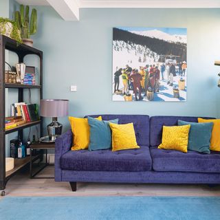 blue living area with blue sofa and yellow cushions