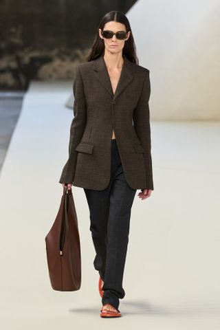 a Tod's model walks the spring/summer 2025 runway in skinny trousers