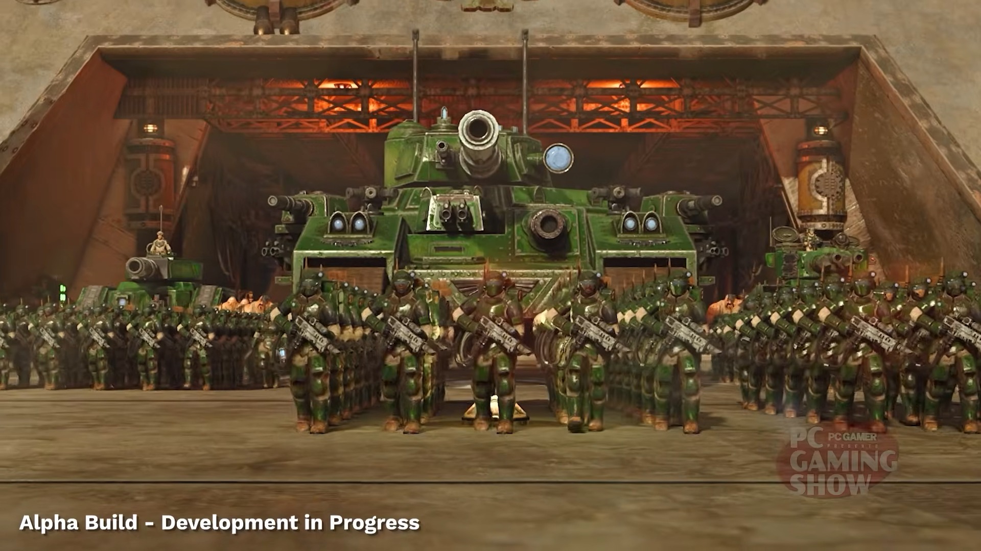 A large green tank flanked by rows of uniformed soldiers stands in a hangar. The atmosphere is tense and military-focused. &amp;ldquo;Alpha Build - Development in Progress&amp;rdquo; text overlays the bottom.