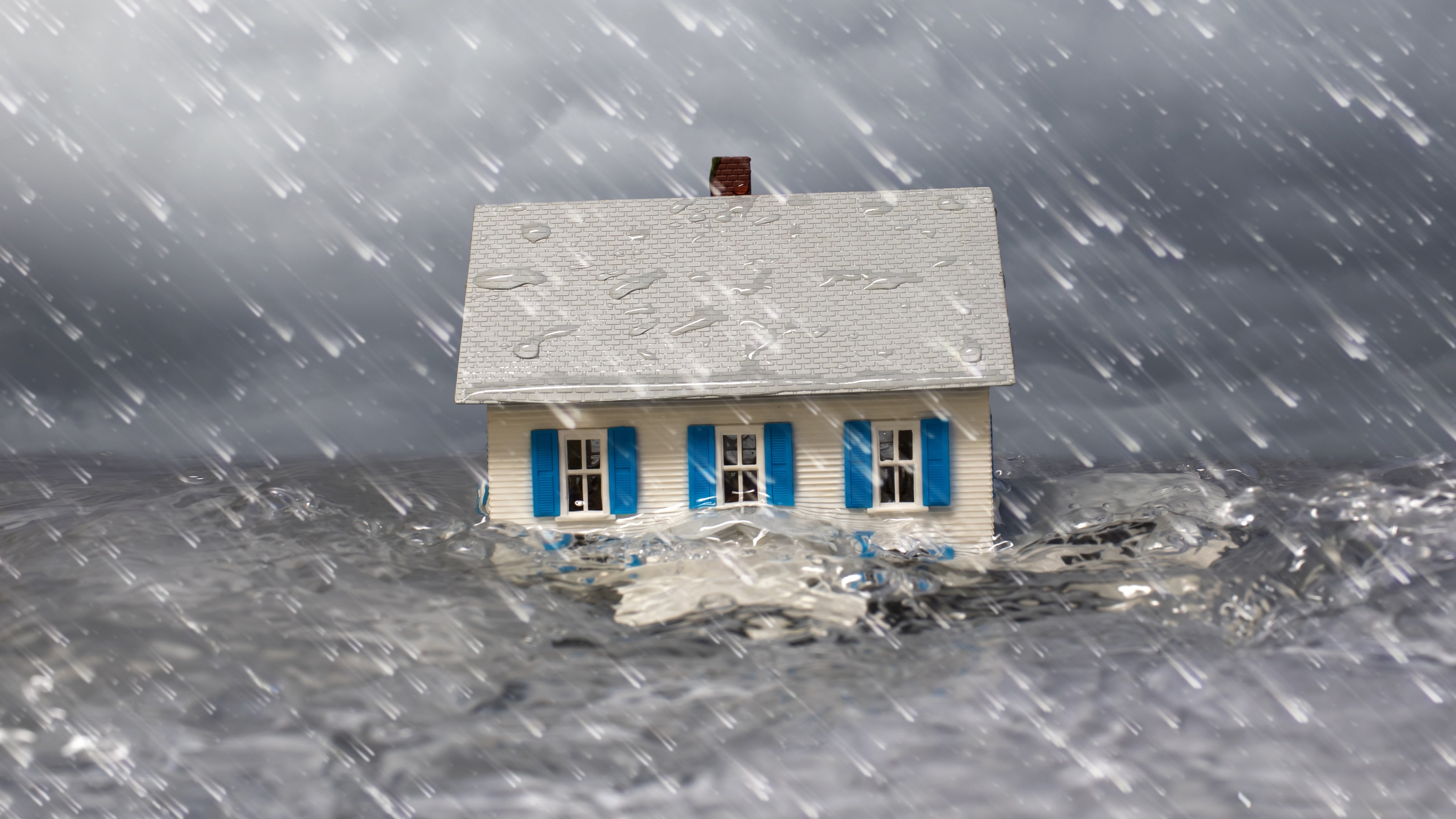 A home appears to be floating away in a flood.