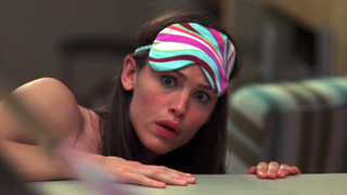 Jennifer Garner as adult Jenna Rink looking at herself in the mirror in horror in 13 Going on 30