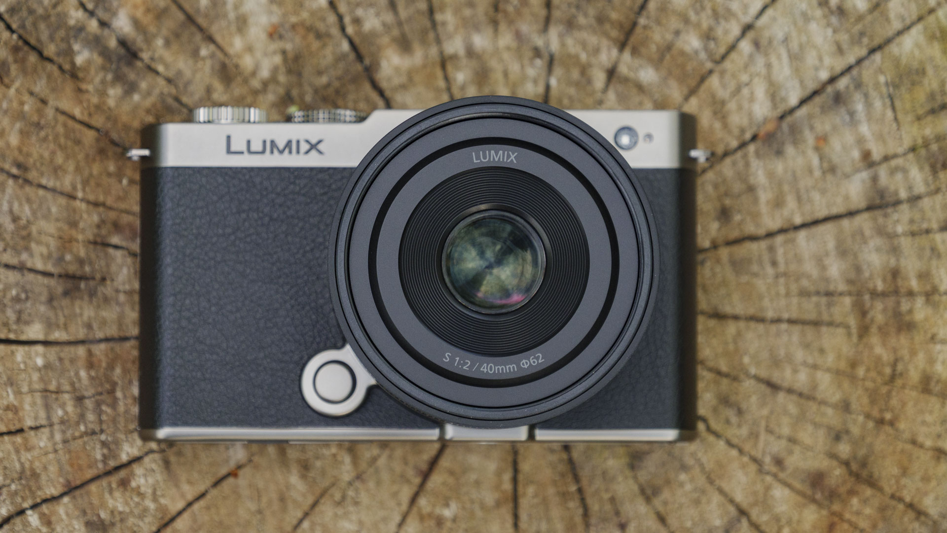 The Panasonic Lumix S 40mm F2 lens attached to a 'titanium' version of the Lumix S9, with natural tree stump backdrop