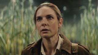 Rebecca Ferguson stands shocked in a corn field in Silo.