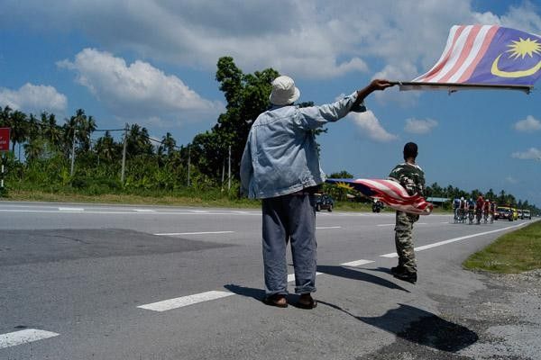 Locals wave the Malaysian flag at the Tour de Langkawi 2006