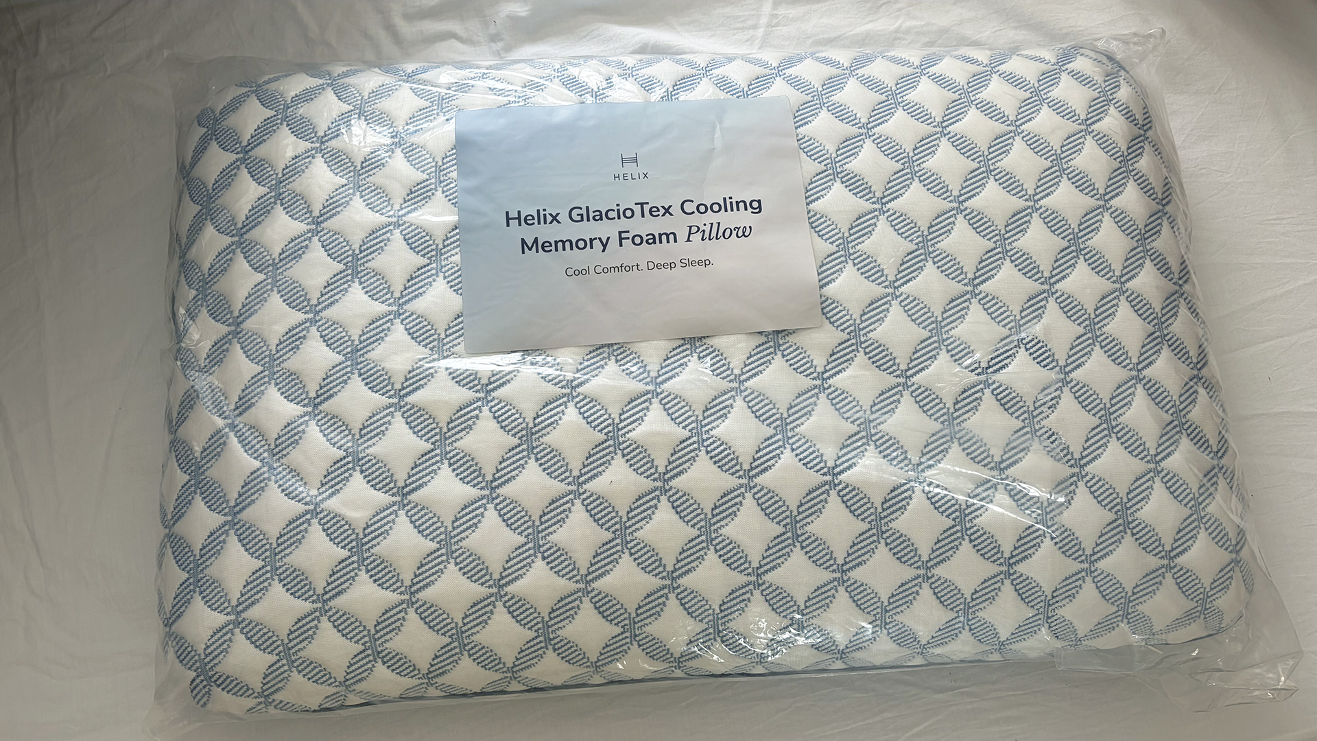 The Helix Cooling Memory Foam Pillow in its packaging, in the reviewer's bedroom