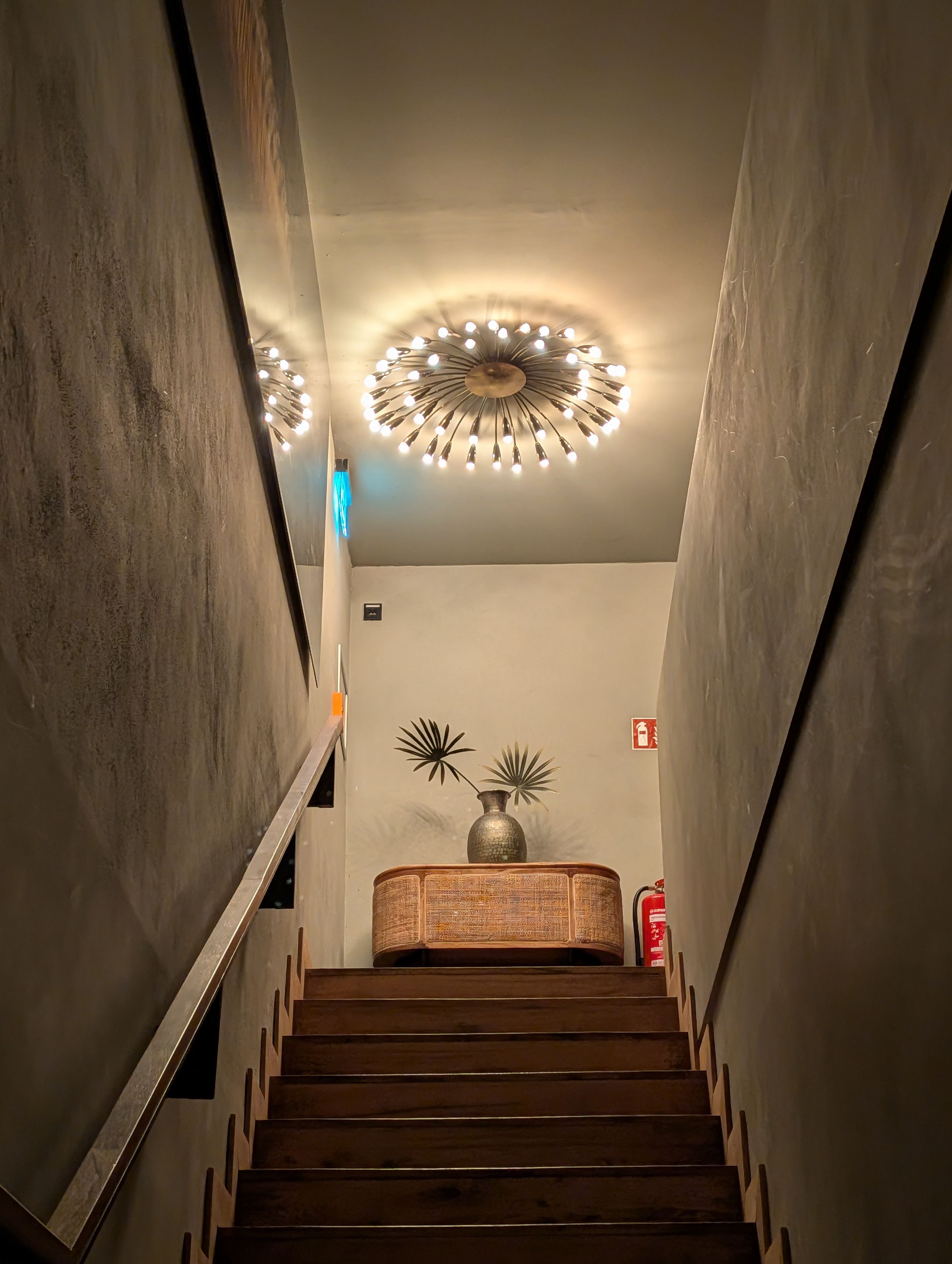 A staircase lit by a chandelier